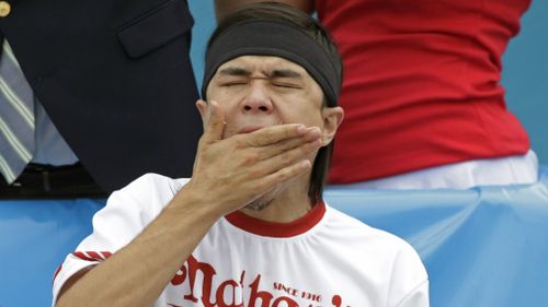 Matt Stonie shovels another dog down. (AAP)