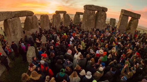 Revellers enjoy the sunrise for the winter solstice at Stonehenge on December 22, 2021 in Amesbury, United Kingdom.