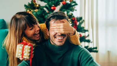 Woman giving man Christmas gift