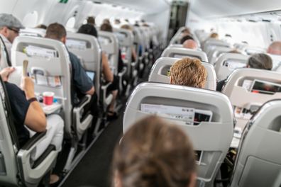 Interior of a commercial airplane with passengers in their seats during the flight.