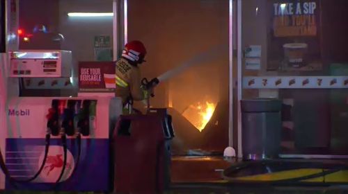 The blaze, which started in the laundromat, quickly spread to the next door petrol station and came dangerously close to gas and petrol tanks. Picture: 9NEWS.