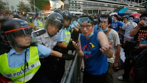 A protester tries to negotiate with riot police as they fire pepper spray in to the crowd. (AAP)