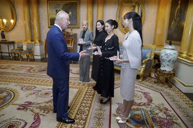 King Charles III (left) presents the members of the K-Pop band Blackpink, from background fourth right,  Rose (Roseanne Park), Jisoo Kim, Jennie Kim, and Lisa (Lalisa Manoban), with Honorary MBEs