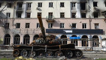 A destroyed tank and a damaged apartment building from heavy fighting are seen in an area controlled by Russian-backed separatist forces in Mariupol, Ukraine.