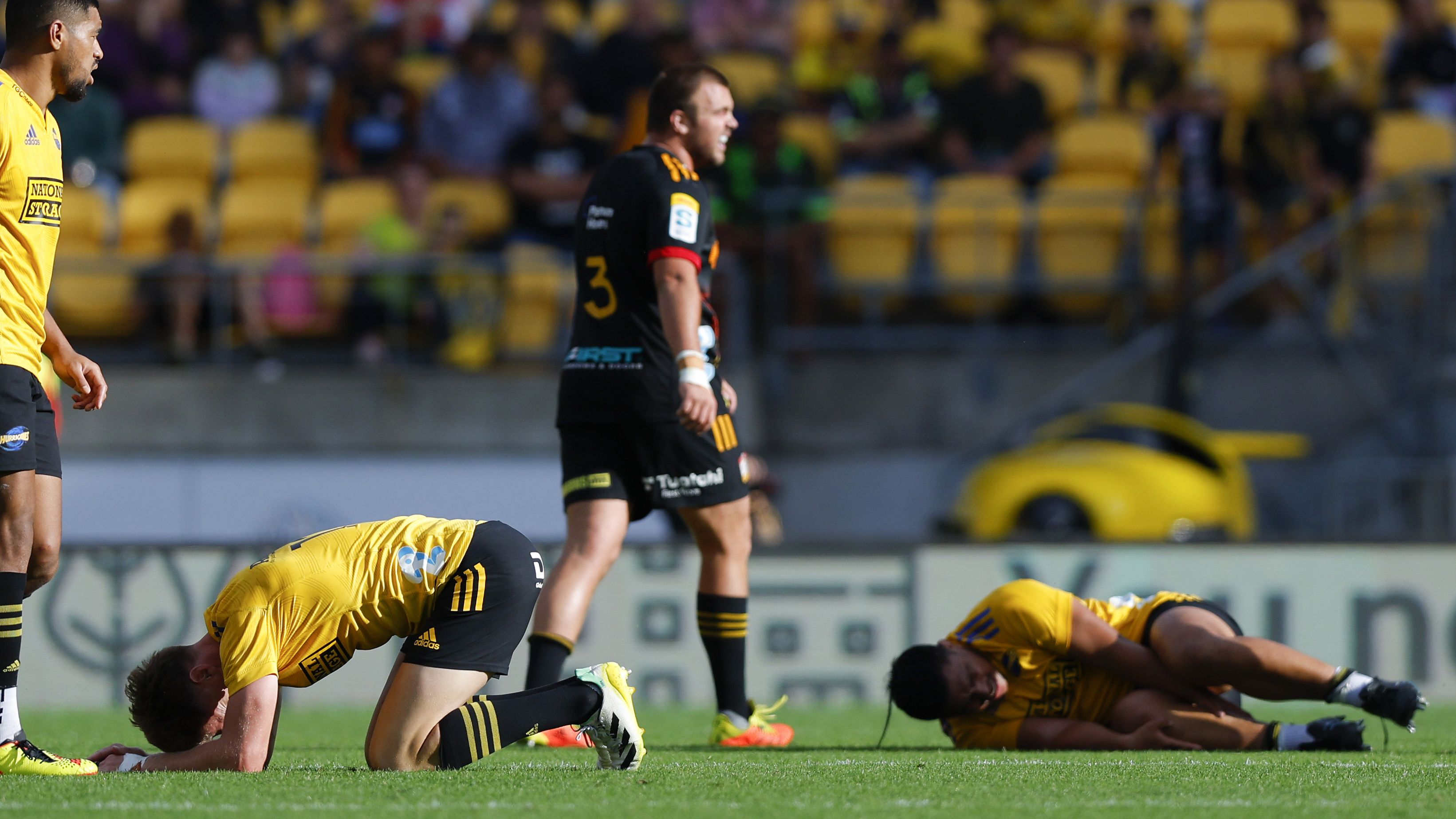 Jordie Barrett and Xavier Numia of the Hurricanes lie on the ground.