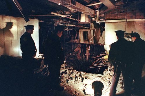 In this Feb. 27, 1993 file photo, Port Authority and New York City Police officers view the damage caused by a truck bomb that exploded in the garage of New York's World Trade Center. It was a terror attack that foreshadowed Sept. 11: the deadly World Trade Center bombing that happened 25 years ago Monday. (AP Photo/Richard Drew, File) 