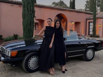 Abbi Jacobson and Jodi Balfour pose in front of a car.