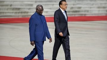 FILE - Solomon Islands Prime Minister Manasseh Sogavare, left, walks with Chinese Premier Li Keqiang during a welcome ceremony at the Great Hall of the People in Beijing.