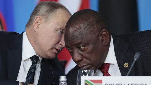 Russian President Vladimir Putin, left, speaks to South African President, Cyril Ramaphosa, right, during a plenary session at the Russia-Africa summit in the Black Sea resort of Sochi, Russia on Oct. 24, 2019.