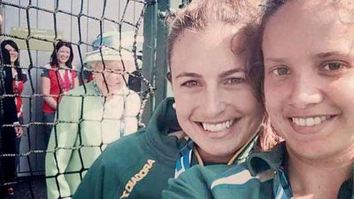 Hockeyroos Jayde Taylor and Brooke Peris, with the Queen behind them. (Twitter)