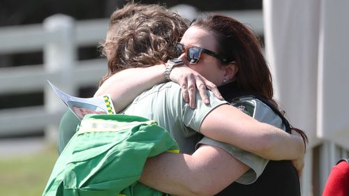 Loved ones embrace at the veteran firefighter's funeral.