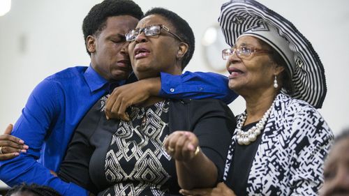 Grant Jean, 15, and his mother Allison Jean, who are the brother and mother of Botham Jean mourn with another churchgoer during a prayer service for Jean at the Dallas West Church of Christ