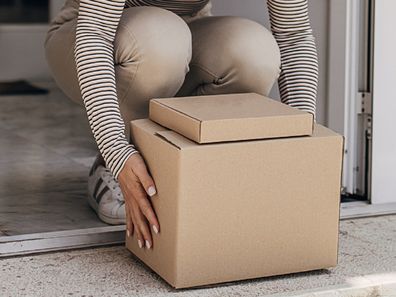 Woman retrieving package at front door