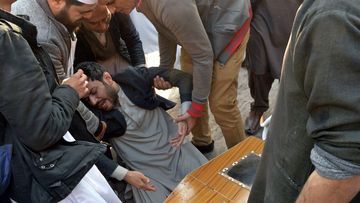 People comfort a man mourning next to coffin of his family member, who was killed in the suicide bombing inside a mosque, at a hospital, in Peshawar, Pakistan.bomber struck Monday inside a mosque in the northwestern Pakistani city of Peshawar, killing multiple people and wounding scores of worshippers, officials said.