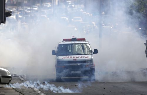A police car emerges through the smoke. Picture: EPA