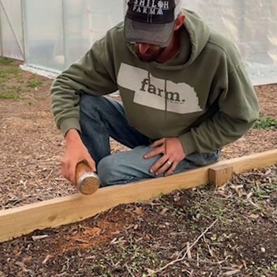 Gardener Noah Young sprinkles cinnamon around his seedlings to deter plant pests