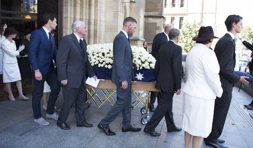 The coffin of Ron Walker is lead away by pallbearers, including former F1 champion Mark Webber (left), after a service at St Paul's Cathedral in Melbourne. (AAP)