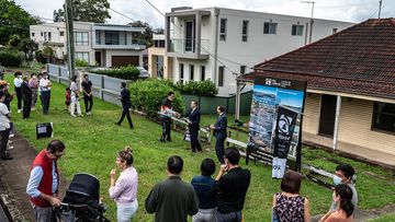Crowds peer at a house auction in Sydney