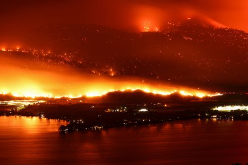 A long exposure image shows the Eagle Bluffs Wildfire, which crossed the border from the U.S. state of Washington, and prompted evacuation orders in Osoyoos, British Columbia, Canada July 30, 2023. 