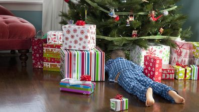 Boy looking under a Christmas tree