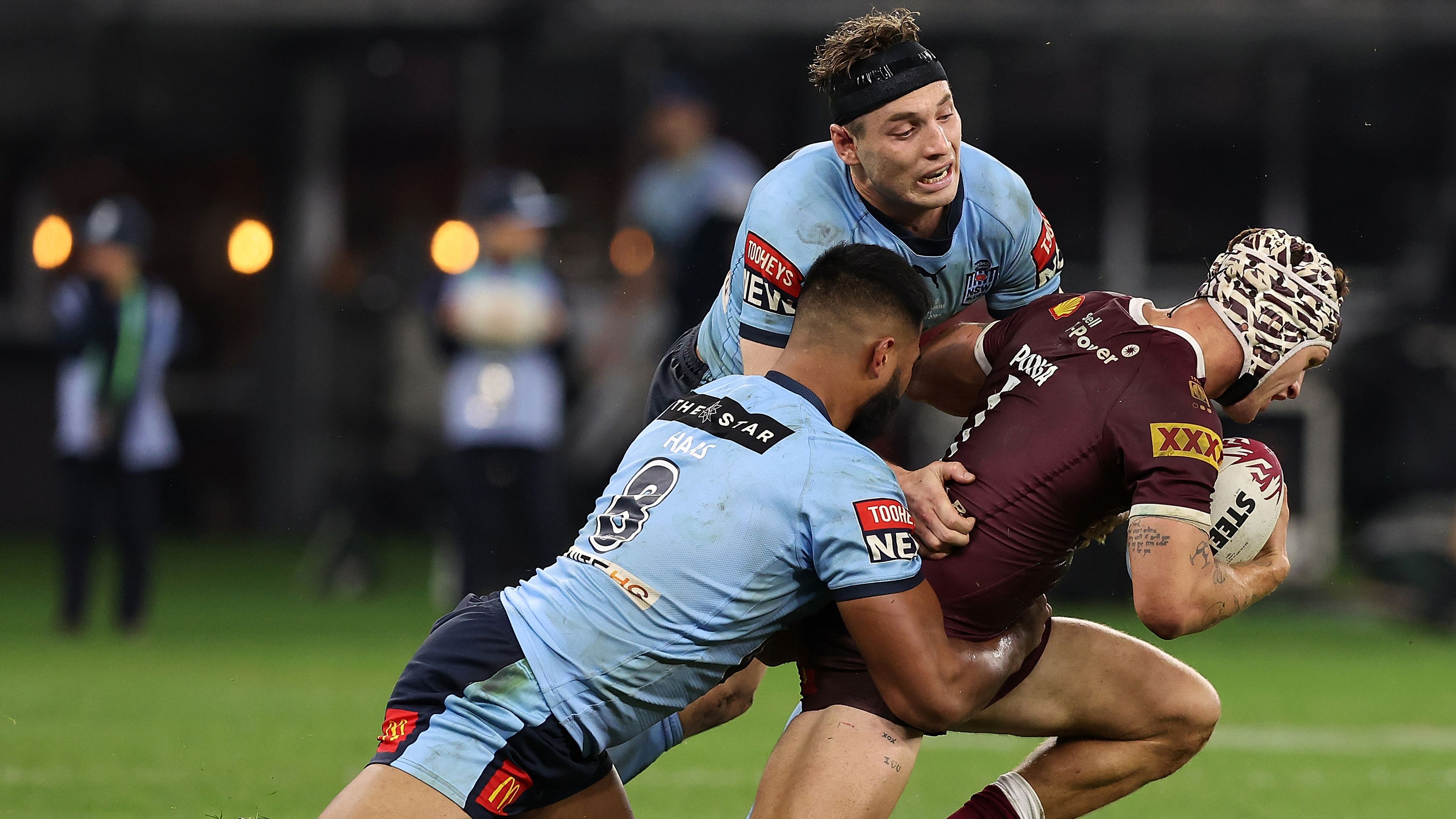 Kalyn Ponga of the Maroons gets tackled by Payne Haas and Cameron Murray of the Blues.