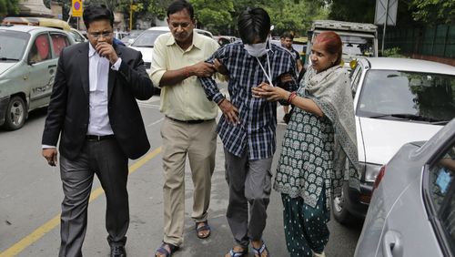 Puneet, second from right, is helped from a New Delhi court by his parents. (Image: AAP)