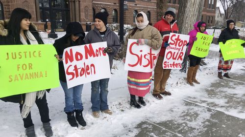 A group of demonstrators stand outside in below-freezing temperatures at the Cass County Courthouse in Fargo, North Dakota, in December 2017.