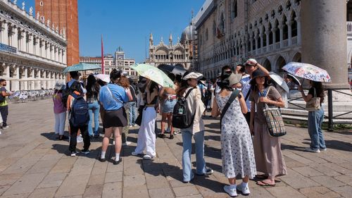 Tourists shelter from the sun in St. Mark's Square as the city gears up for 'Redentore' festival celebrations in Venice, Italy, earlier this month.