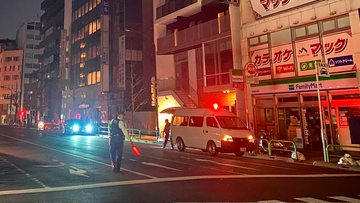 A policeman stands on a street during a black out in Tokyo Thursday, March 17, 2022, following an earthquake.