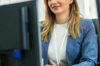 Stock image of woman using computer in her office job