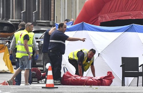 Authorites work to clear the scene of the shooting, where two female police officers and an innocent bystander were shot dead. Picture: AP