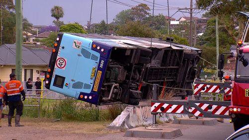 Le véhicule a percuté une barrière en béton et deux hommes à bord ont été éjectés du bus après l'accident de Lake Macquarie, NSW.