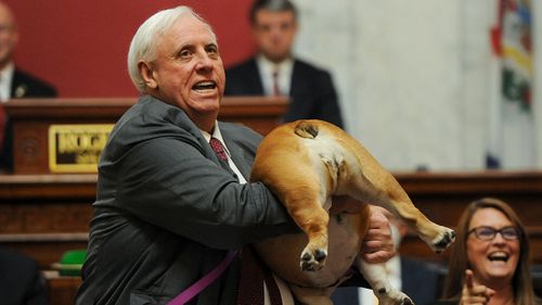 West Virginia Gov. Jim Justice holds up his dog Babydog's rear end as a message to people who've doubted the state.