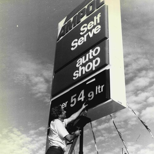 The manager of the Ampol Service Station on Anzac Parade in Sydney's east changes the petrol prices on his sign, in 1987.