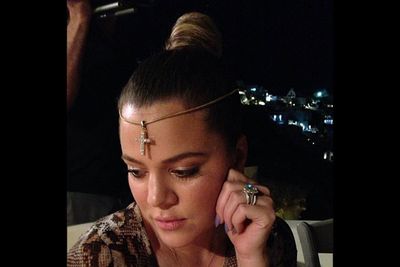 Khloe does her best <i>Neverending Story</i> impersonation with this crucifix necklace. Sacrelicious.