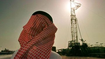 An official of the Saudi oil company Aramco, watches progress at a rig at the al-Howta oil field near Howta, Saudi Arabia. 