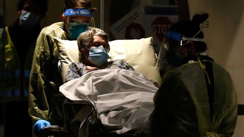 A resident of a Melbourne aged care facility is taken away in a ambulance.