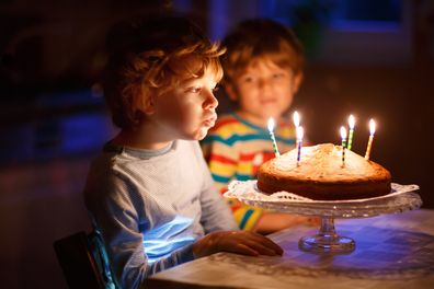 Young boy's birthday. Young boy blowing out candles. Young boy with birthday cake. 