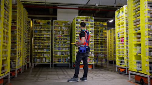 A maintenance employee works in a robotic warehouse at Amazon's centre of Bretigny-sur-Orge in December 2021.
