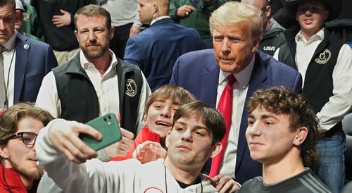 Former President Donald J. Trump, right, poses for photos at the NCAA Wrestling Championships, in Tulsa
