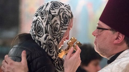 Ms Kemaeva kisses a cross during Kemaev's funeral service at St. Nicholas Orthodox Church in Mckees Rocks, Pennsylvania. (AAP)