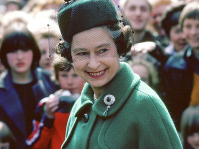 Worcester, England, in 1980, Queen Elizabeth wears the Round Cambridge Emerald brooch, which belonged to her great-grandmother, Princess Mary Adelaide of Cambridge, Duchess of Teck.