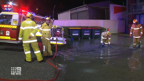 Emergency services work to pump water out of the flooded carpark in Perth.