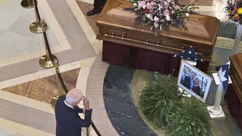 Former President Joe Biden makes a sign of the cross as he pays his final respects to former Minnesota House Speaker Melissa Hortman, her husband, Mark, and their golden retriever, Gilbert