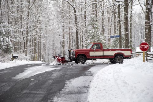 A snow plough operator clears a private road after a winter storm dumped a blanket of snow in Fairfax Station, Virginia.