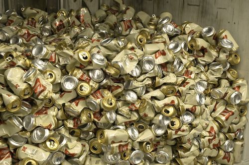 Cans of Miller High Life beer sit in a container after being crushed at the Westlandia plant in Ypres, Belgium, Monday, April 17, 2023.  