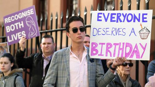 Anti-abortion protesters hold signs during a rally outside the New South Wales Parliament house in Sydney.