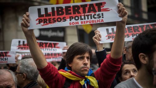 Demonstrators holding banners that read in Catalan: "Freedom for the Political Prisoners" gather outside the Palau Generalitat during a general strike in Barcelona, Spain. (AAP)