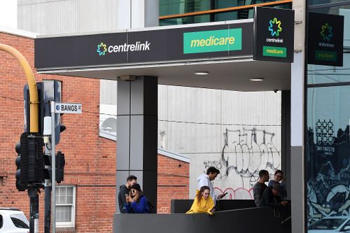 People are seen waiting in line at the Prahran Centrelink office in Melbourne, Tuesday, March 24, 2020. 