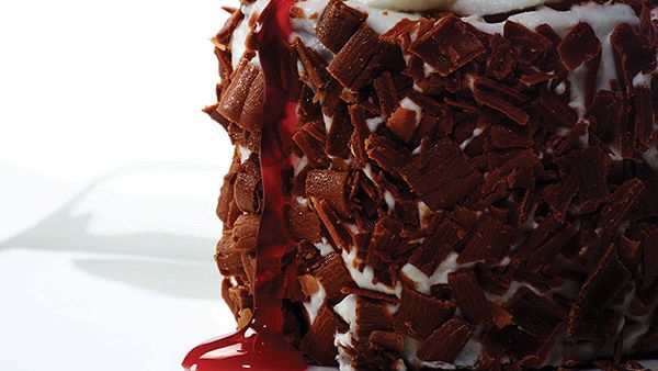 Spy-thriller chocolate Black Forest cake covered with alpine whipped cream and cherry, the German double agent on top
